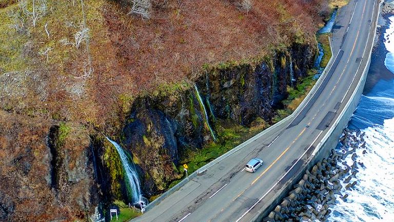 道路脇の崖を流れる「フンベの滝」の不思議な光景|Domingo